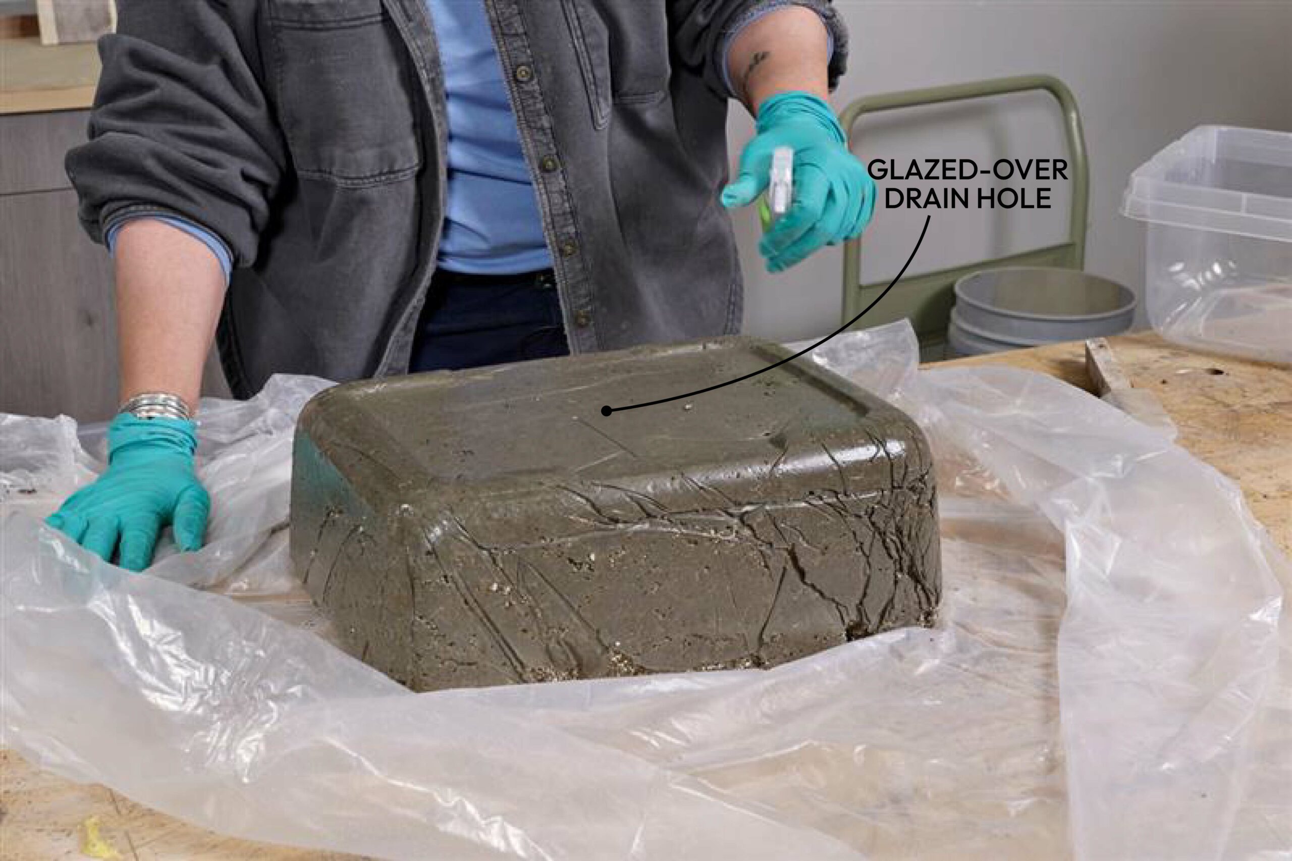 While drying, the drain hole may become glazed over with a thin layer of cement