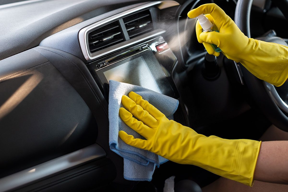 Wiping down surface of car dashboard