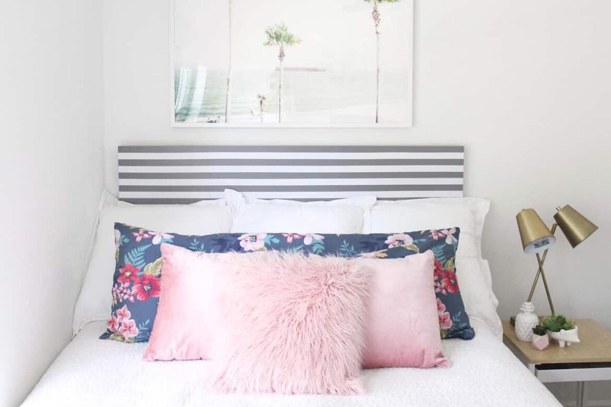 Bed with striped headboard and pink pillowcases