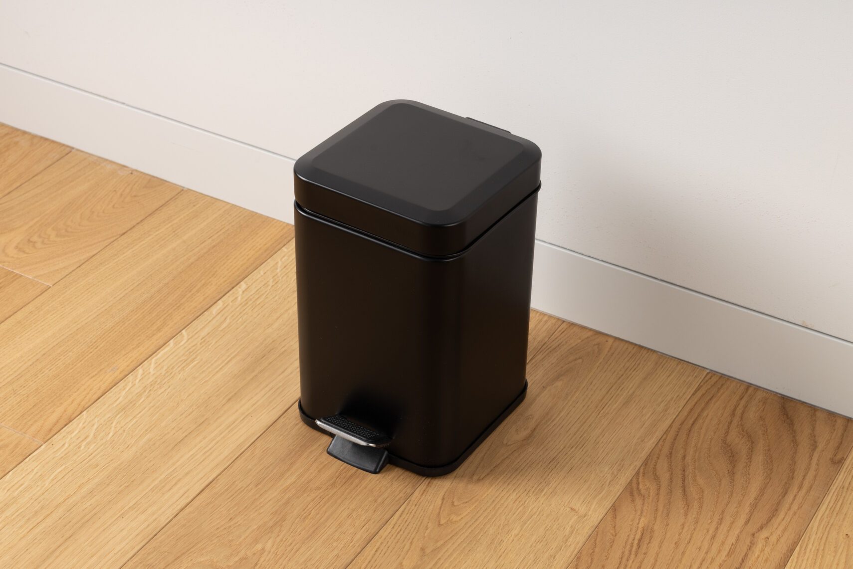 Black Pedal Trash Bin on Wooden Floor
