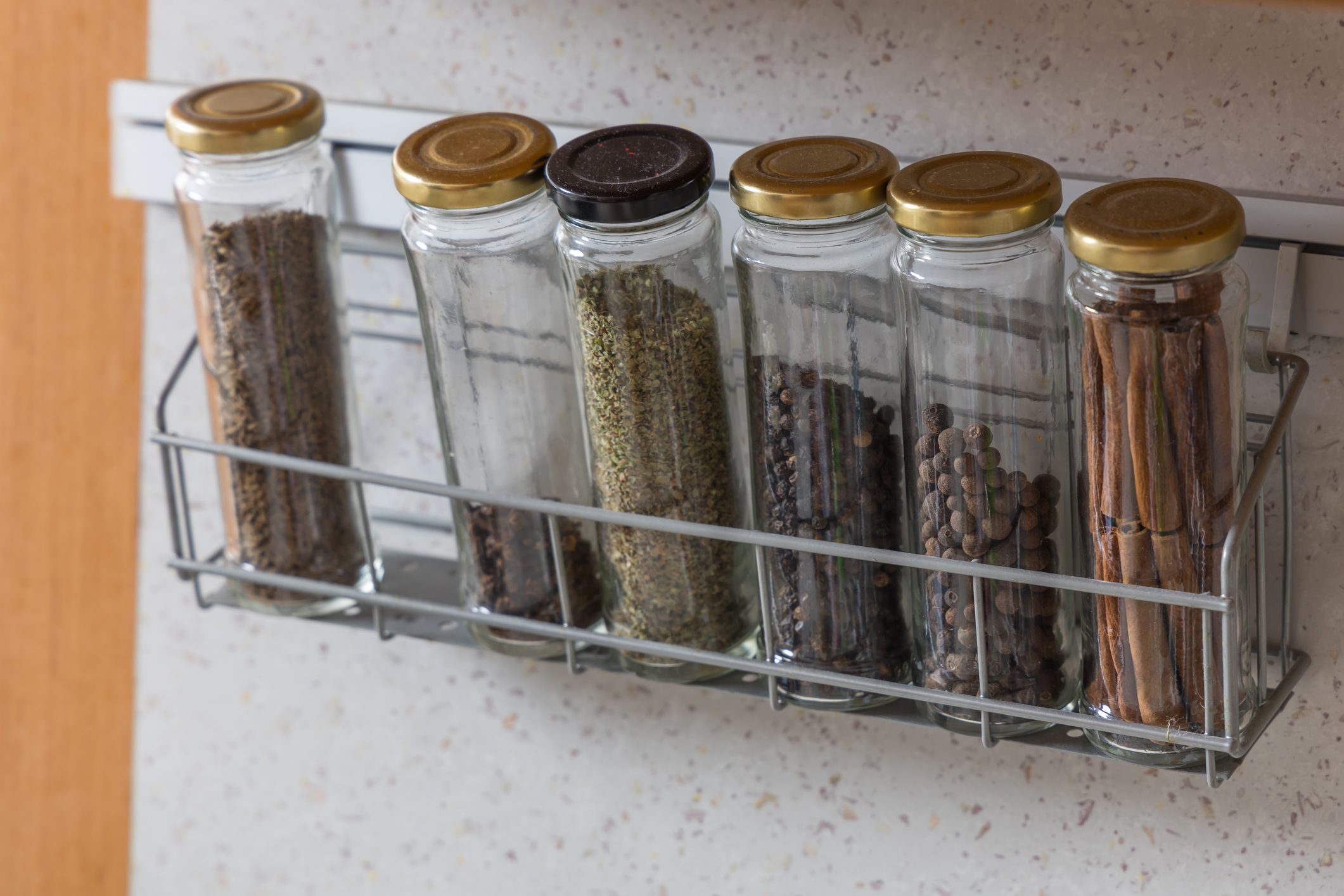 Spices in jars stored on a shelf in the kitchen