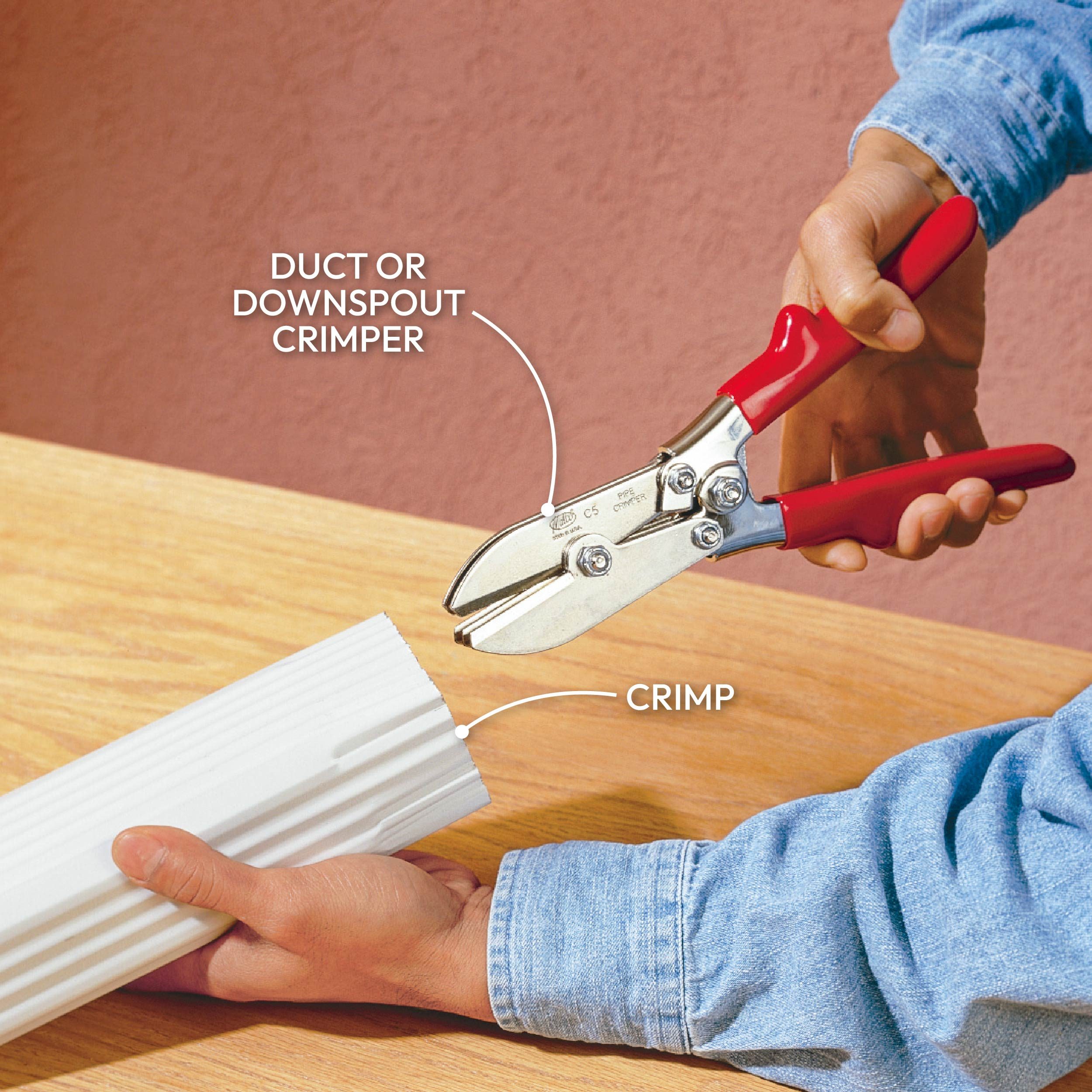 A person uses a crimper on a white material to create a crimp, with a wooden surface and a pink wall in the background.
