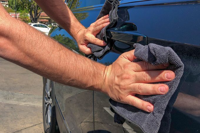 A man cleaning car with microfiber cloth