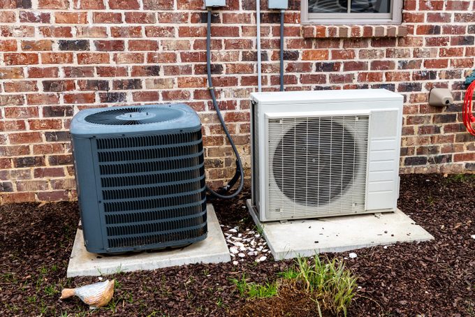 Mini-split air conditioner unit and full Compressor next to home, with copy space