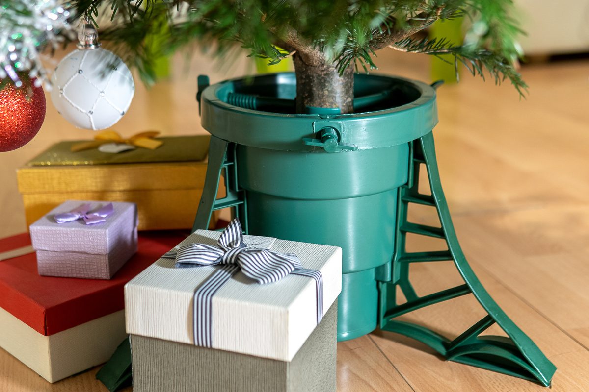 gift boxes next to plastic christmas tree stand