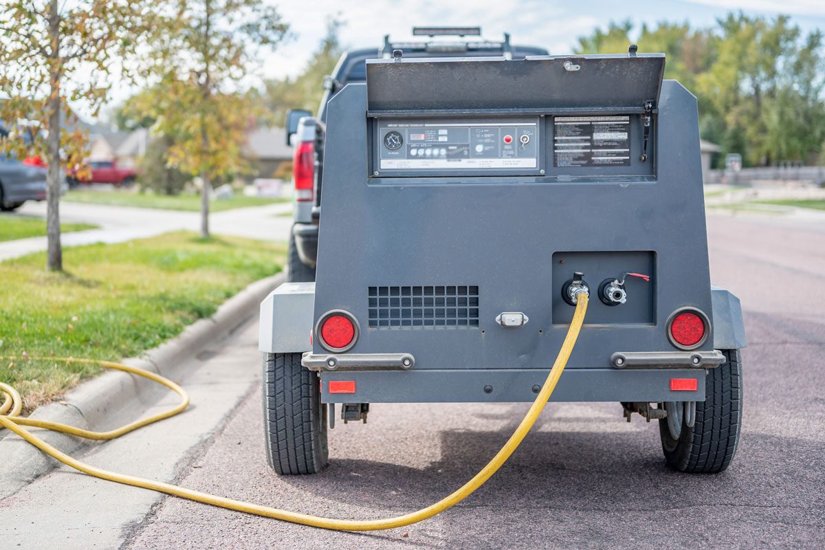 Winterizing a residential irrigation system by using a compressor and forced air to blow the lines empty