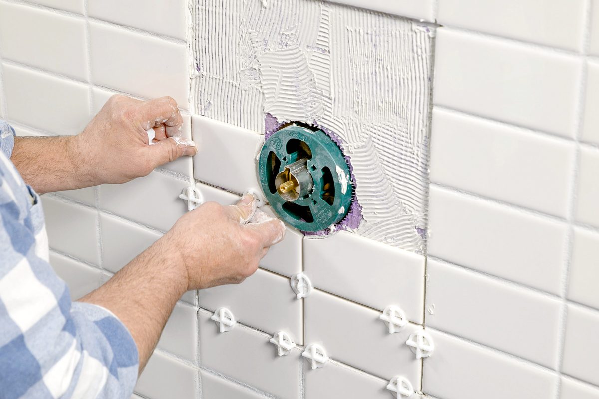 repairing wall and tile after completing plumbing work