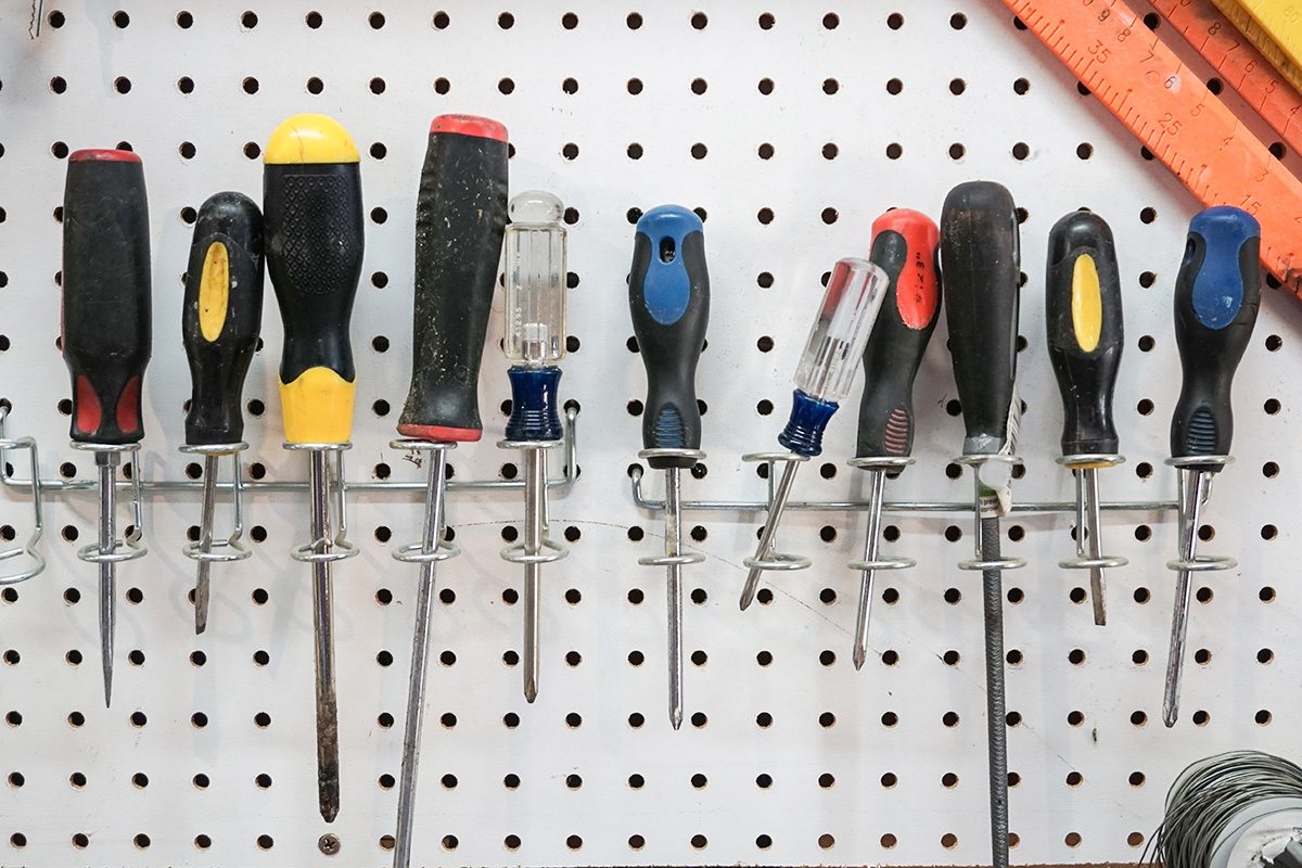 A collection of screwdrivers hanging from a pegboard