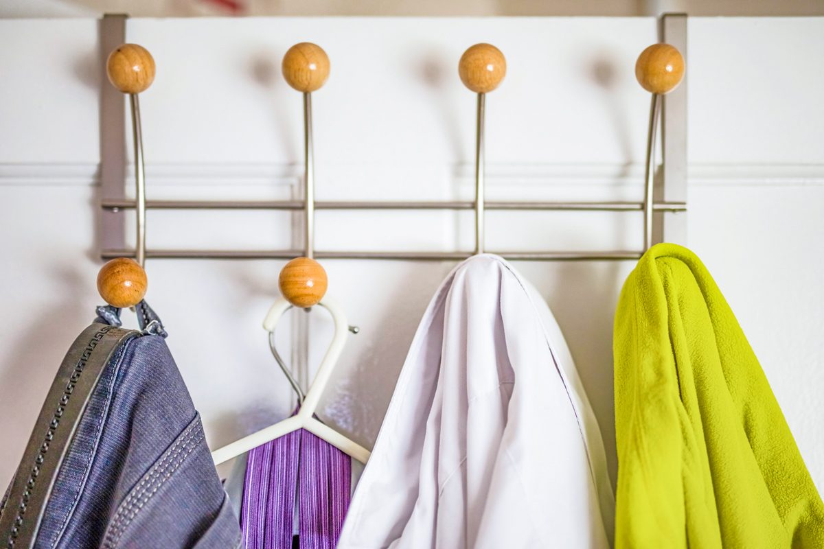 clothes on metal hanger behind closet door