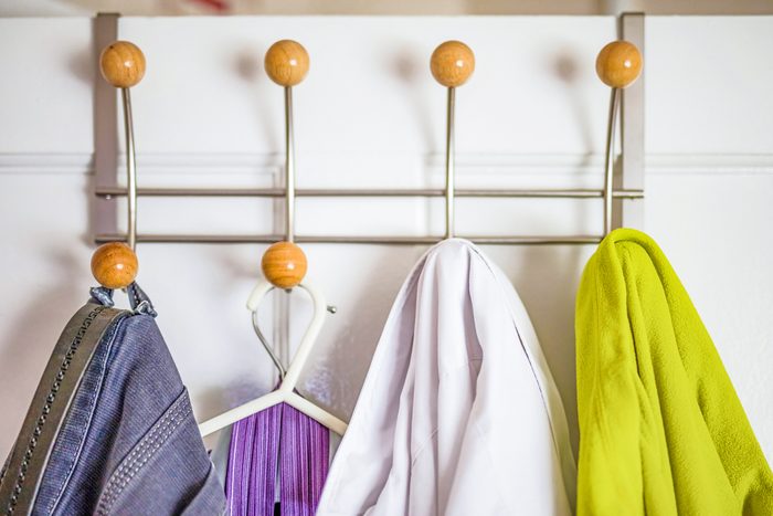 clothes on metal hanger behind closet door
