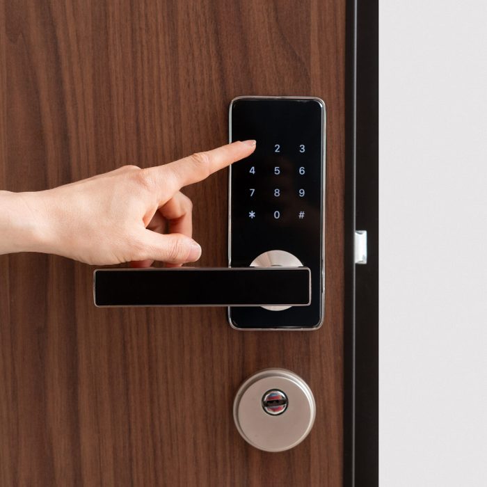 Person entering password code on digital door lock