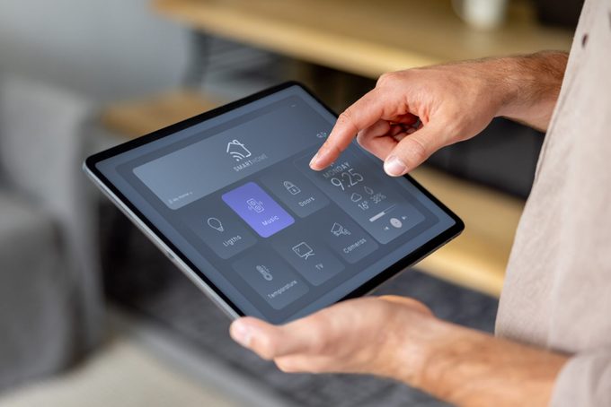 Man controlling the music at home using a digital tablet