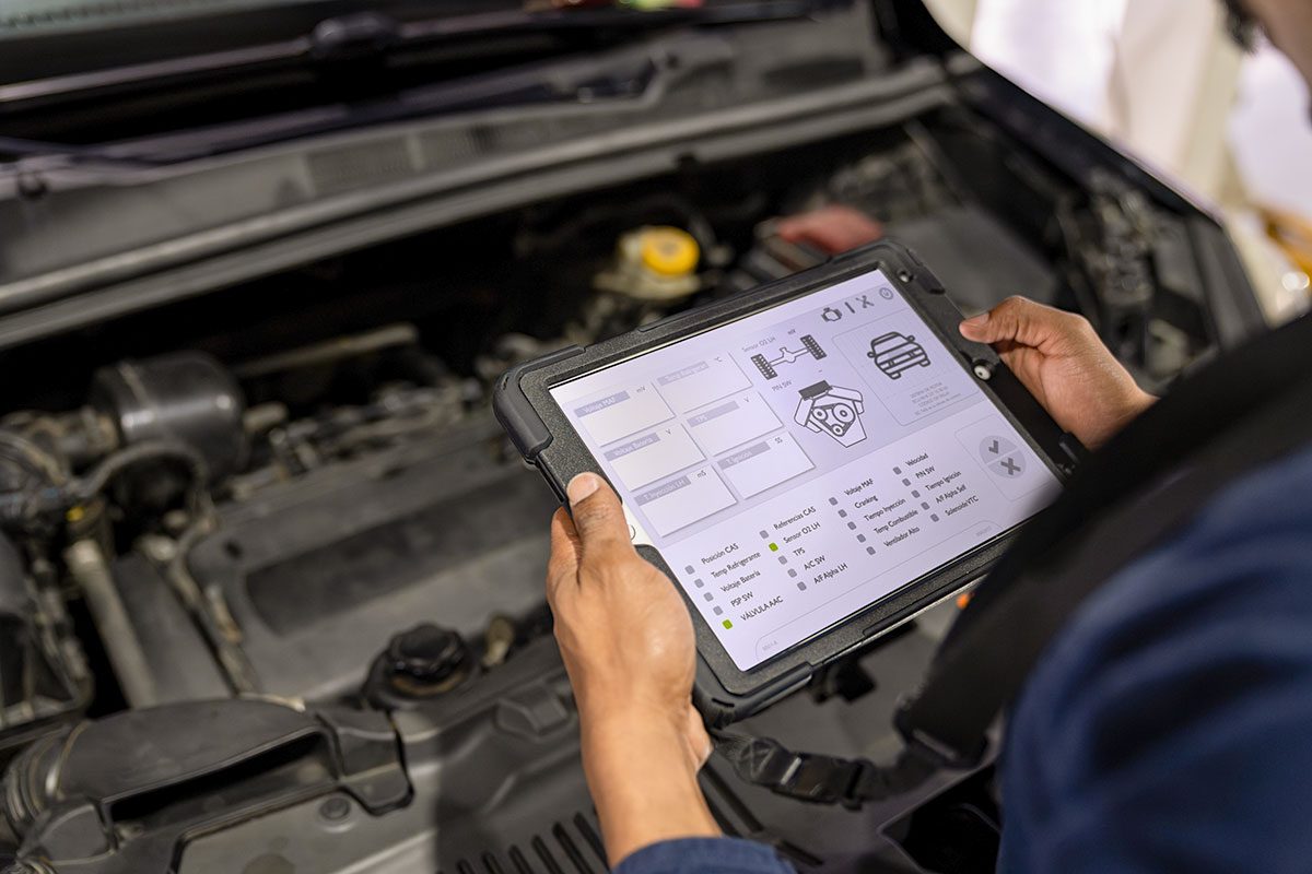 Mechanic using a scanner while making a diagnosis on a car at the auto repair shop