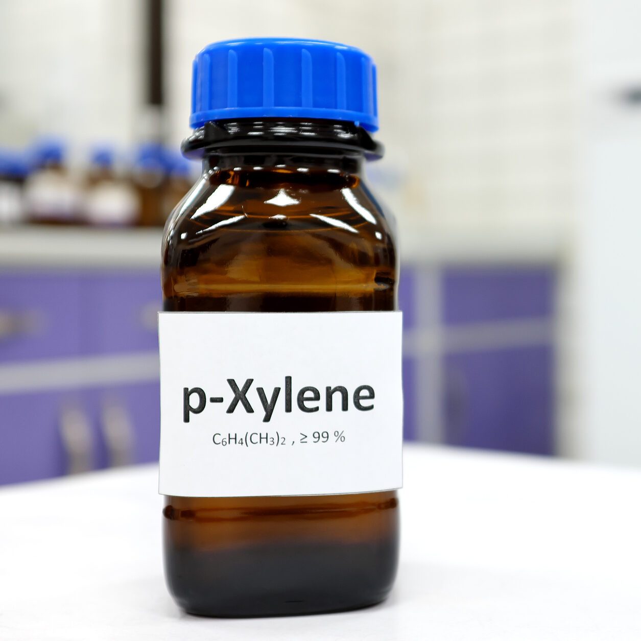 Selective focus of xylene liquid chemical compound in dark glass bottle inside a chemistry laboratory with copy space. Aromatic hydrocarbon used in petrochemical industry.
