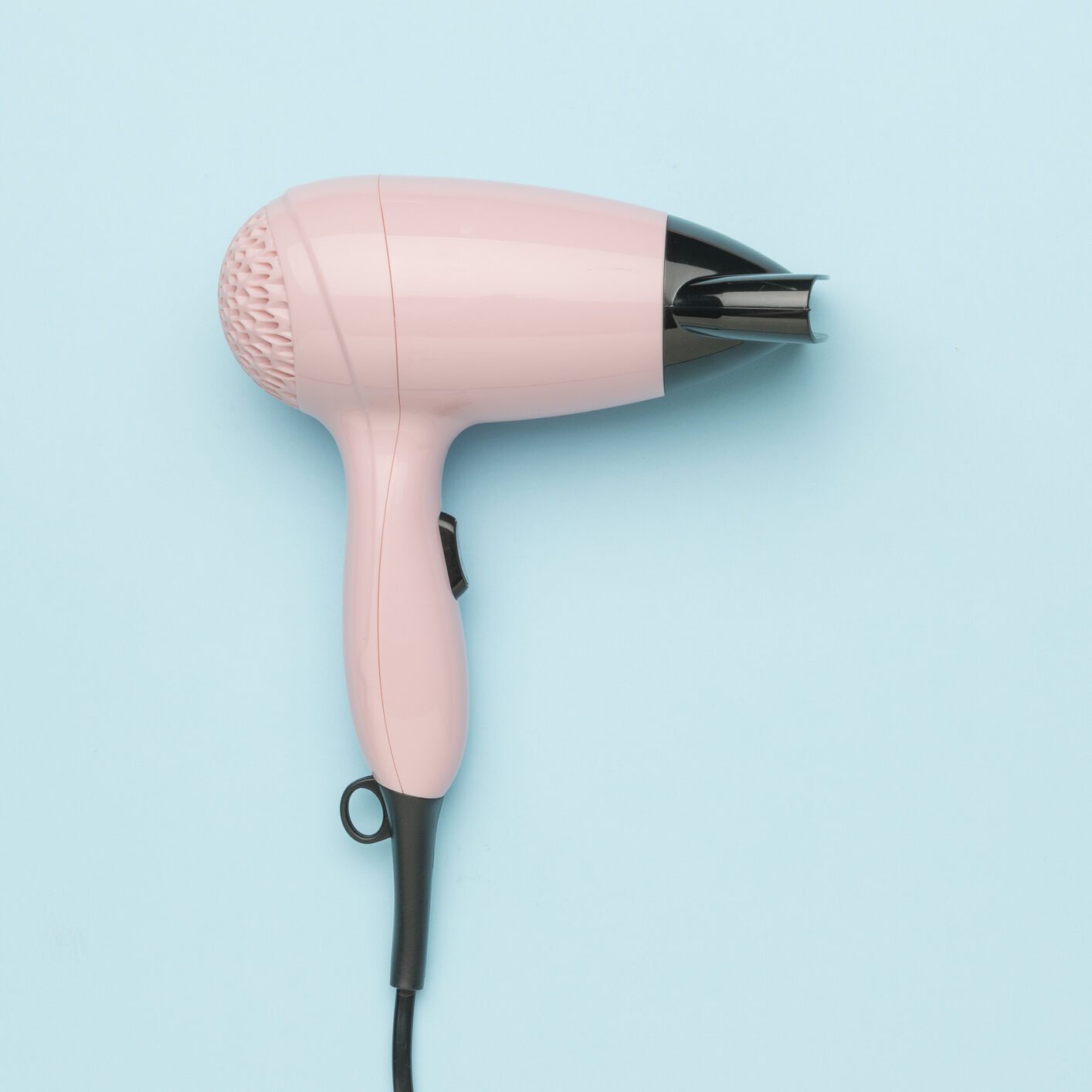 Pink Hair Dryer on Light Blue Background - Modern Beauty Appliance for Stylish Hair Care