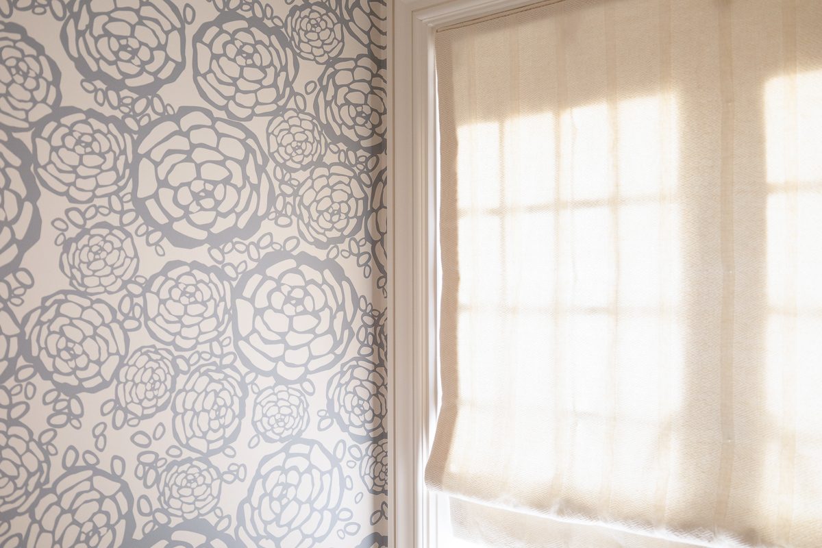 roman window shades next to wall with floral pattern design