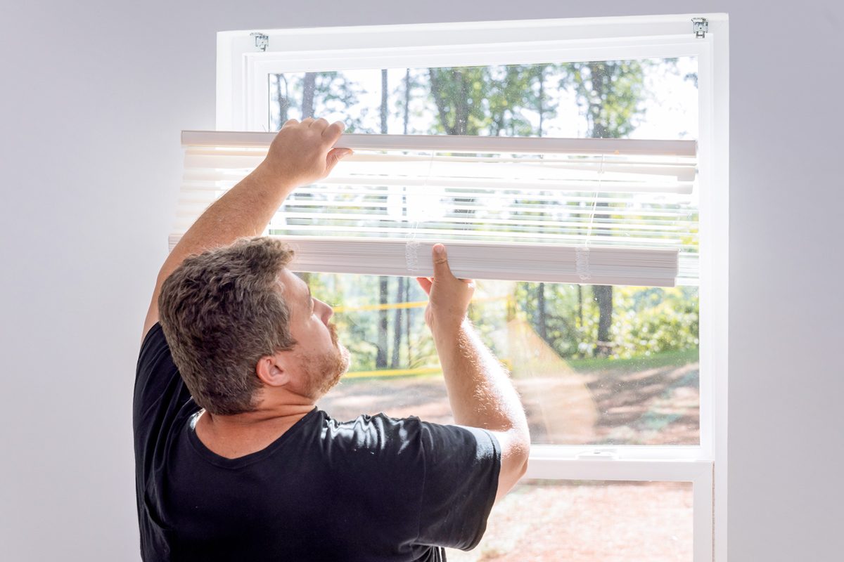 man mounting window shades